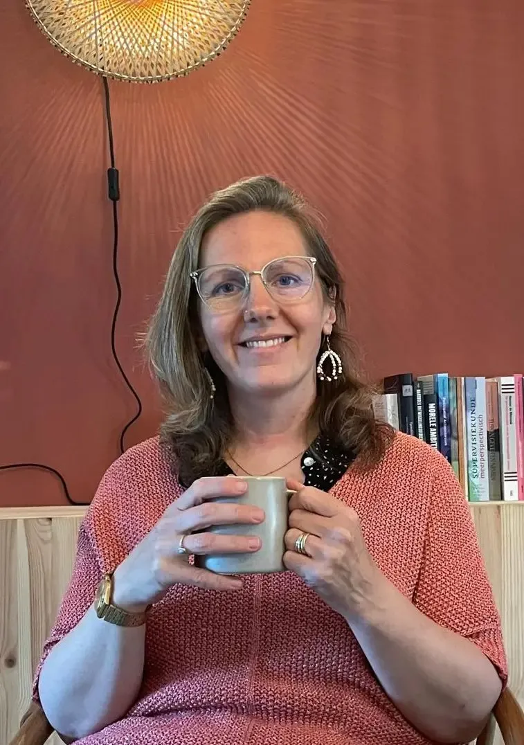 Corine Jacobs met een kop thee in haar praktijkruimte